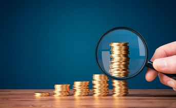 Magnifying glass inspecting the tallest stack of coins in a row