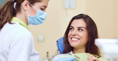 a patient smiling after receiving her dental crowns