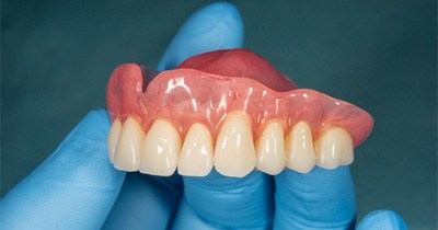 closeup of dentist holding denture