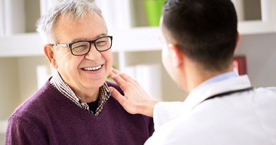 Patient with dentures in Grafton smiles at his dentist