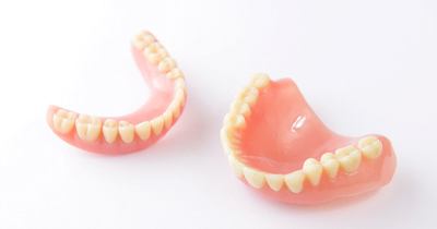 Set of full dentures in Grafton on white background
