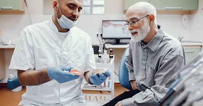 a dentist explaining how dentures work to a patient