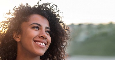 person smiling and taking a walk outside