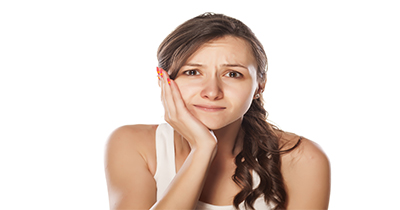 sad young woman holding her hand on her jaw