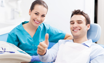 Smiling man in dental chair giving thumbs up