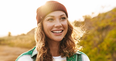 a smiling woman walking in nature