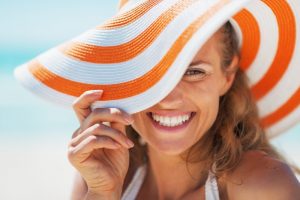 Woman in sun hat smiles after visiting her Grafton cosmetic dentist