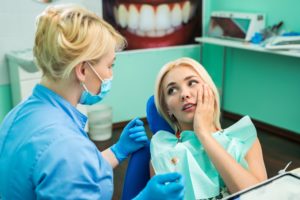 Woman with loose tooth in dental chair