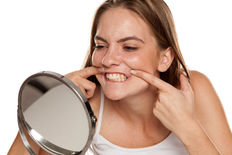Patient smiling in the mirror after getting dental implants